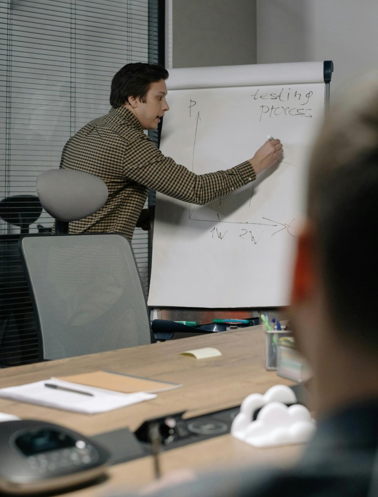 Professional presenting to board in glass-walled boardroom